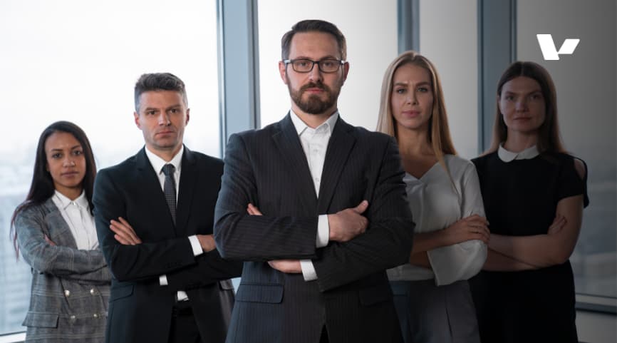 A group of confident professionals standing together in a modern office setting, showcasing teamwork and leadership.