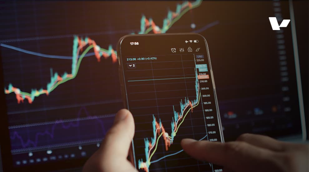 Close-up of a hand using a mobile device to analyze stock market data, with AI-related digital graphics in the background.