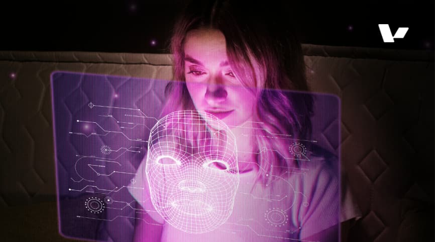 A woman interacting with a futuristic holographic AI interface displaying a digital face, symbolizing the connection between humans and artificial intelligence in modern technology.